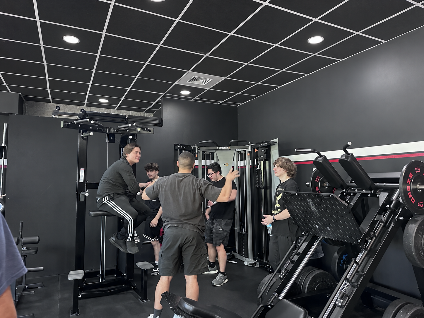 A trainer demonstrating a movement to a small group in the gym.